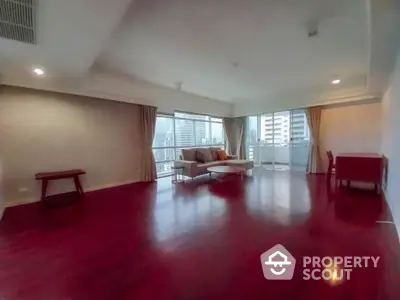 Spacious modern living room with city view and elegant hardwood floors.