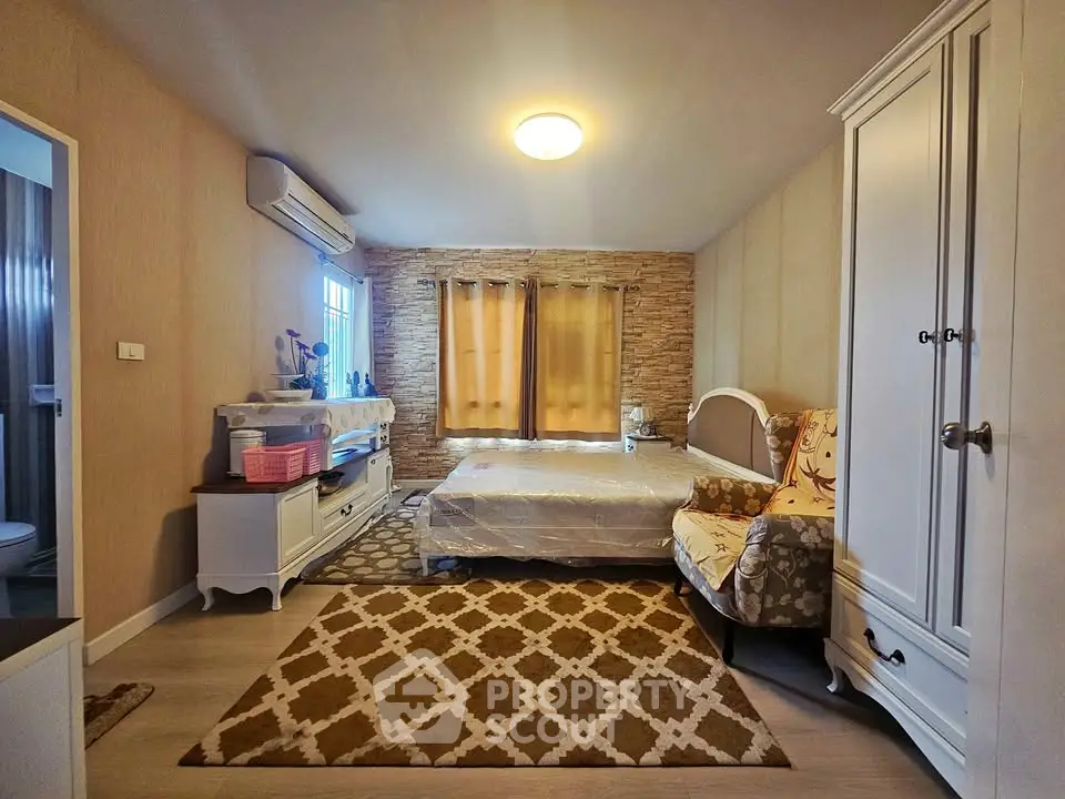 Cozy bedroom with stylish decor and ample natural light, featuring a comfortable bed and elegant furnishings.