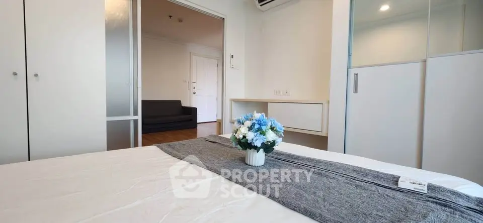 Modern bedroom with stylish decor and ample storage in a cozy apartment.