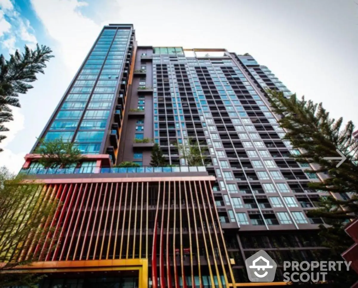 Stunning modern high-rise building with sleek design and vibrant facade in urban setting.