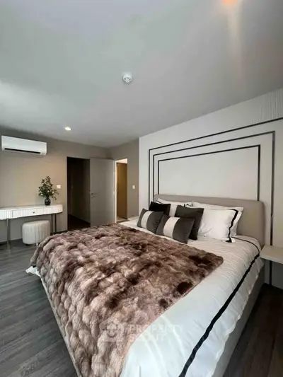 Luxurious bedroom with plush bedding and modern decor, featuring elegant lighting and stylish furnishings.