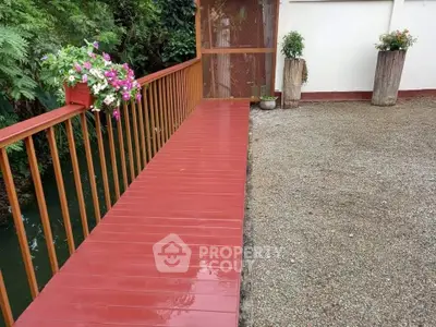 Charming garden area with wooden walkway and vibrant flowers, perfect for relaxation.
