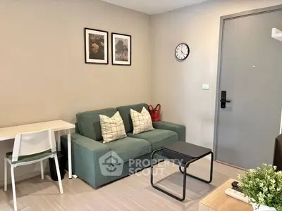Cozy living room with modern decor, green sofa, and wall art in a stylish apartment.