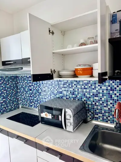 Modern kitchen with mosaic backsplash and microwave oven