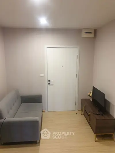 Cozy living room with modern sofa and TV stand, perfect for relaxation.