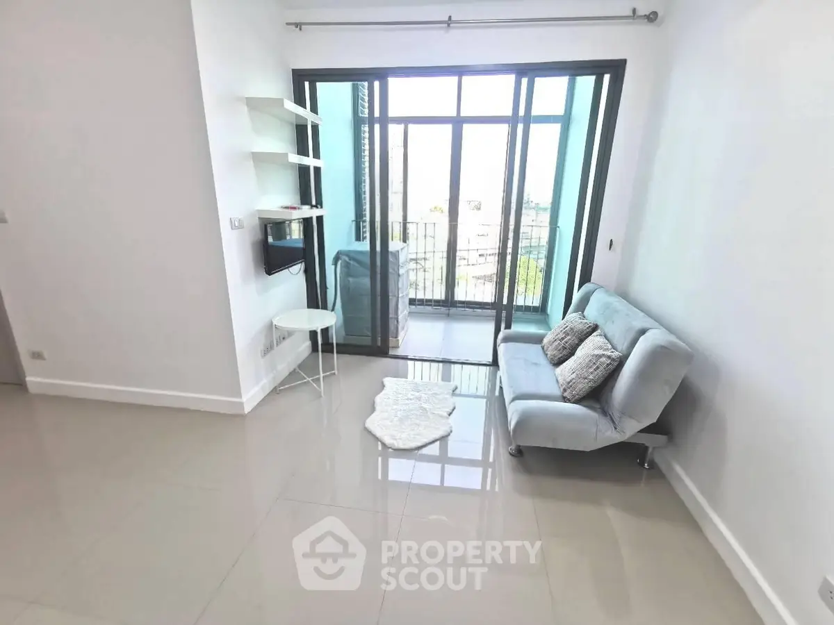 Modern living room with sleek sofa and balcony view in a stylish apartment.