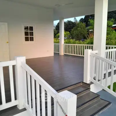 Charming outdoor patio with elegant railing and lush greenery view