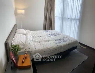 Modern bedroom with large window and stylish decor in a high-rise apartment.
