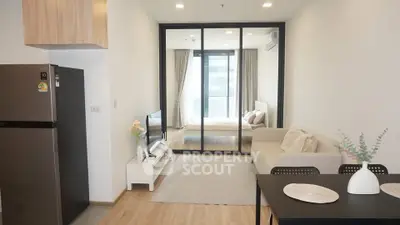 Modern open-plan living room with cozy bedroom view and sleek kitchen area.