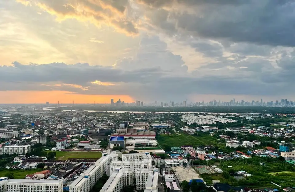 Stunning cityscape view with vibrant sunset over urban skyline and lush greenery.