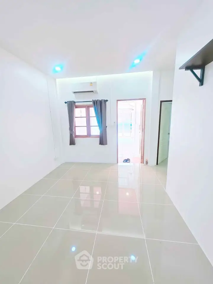 Bright and spacious living room with modern tile flooring and natural light.