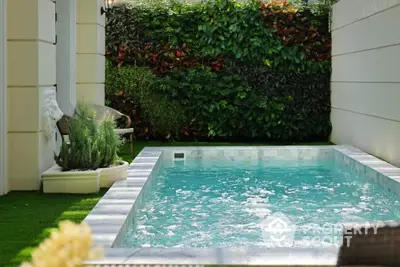 Luxurious private pool with lush garden surroundings in elegant residential setting.