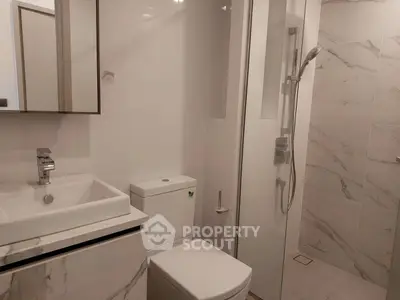 Modern bathroom with sleek fixtures and marble accents in a contemporary real estate property.