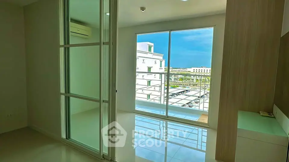 Bright modern apartment with large windows and balcony offering stunning city views.