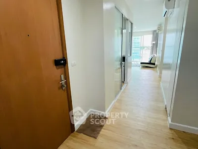 Spacious apartment hallway leading to a bright living area with modern decor.