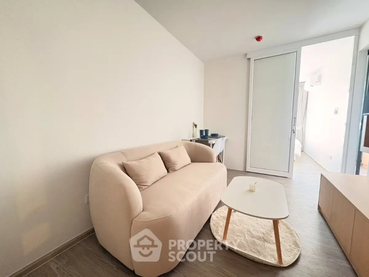 Modern living room with cozy beige sofa and sleek coffee table in minimalist apartment.