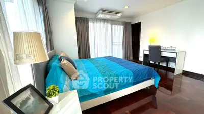 Spacious bedroom with modern decor and large windows for natural light