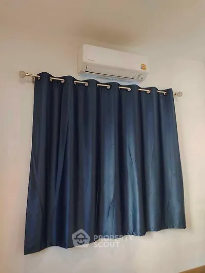 Modern room with air conditioning and elegant blue curtains.