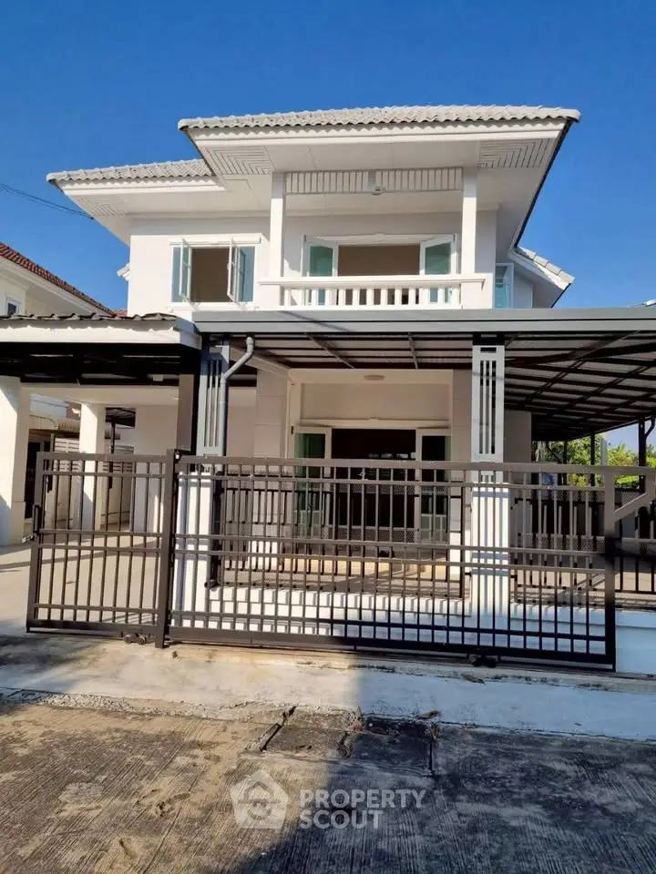 Stunning modern two-story house with spacious balcony and sleek gated entrance.