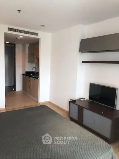 Modern studio apartment with open kitchen and cozy living area.