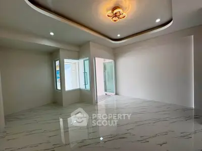 Spacious modern living room with elegant ceiling lights and glossy marble flooring.