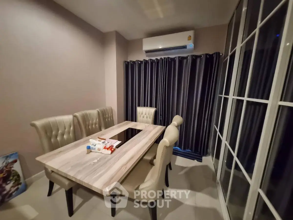 Elegant dining room with modern table, plush chairs, and air conditioning, perfect for family gatherings.