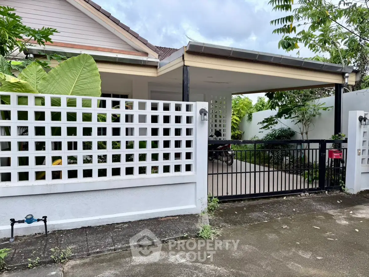 Charming suburban home with gated driveway and lush greenery