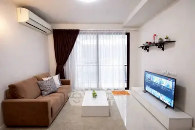 Modern living room with sleek furniture and large TV, perfect for relaxation and entertainment.