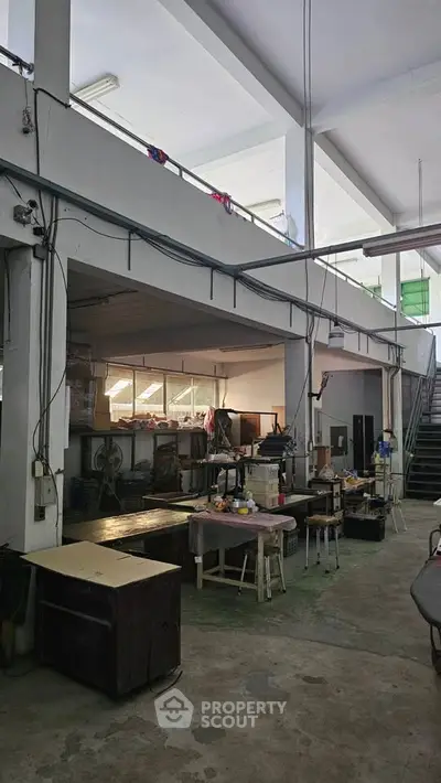 Spacious industrial warehouse interior with high ceilings and mezzanine level.