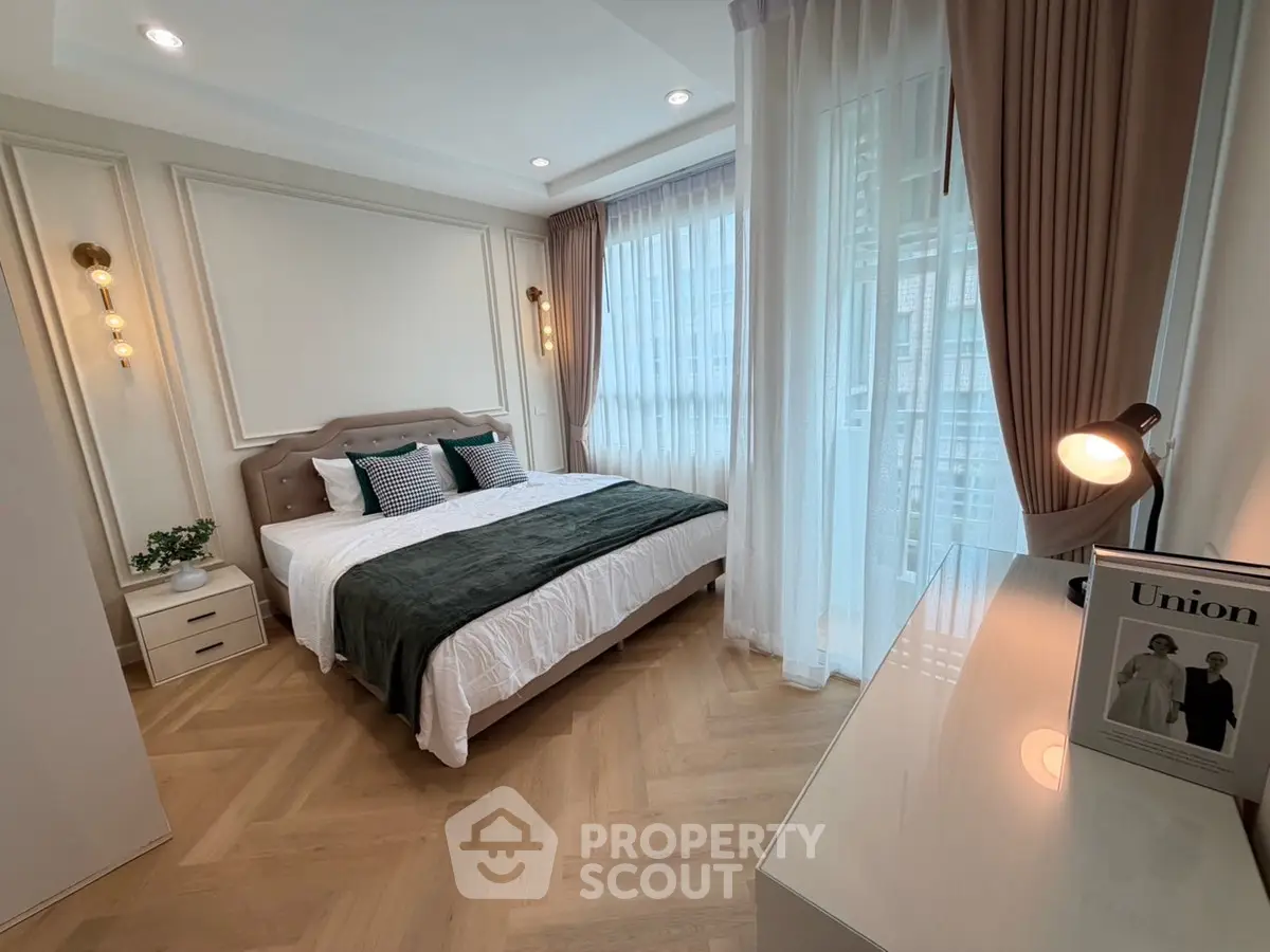 Elegant bedroom with modern decor and large windows for natural light.