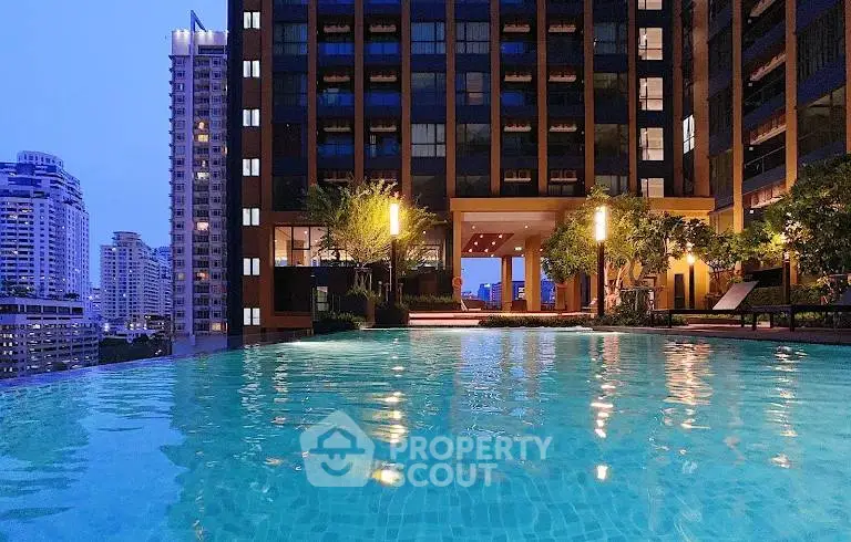 Luxurious high-rise building with stunning rooftop pool and city view at dusk.