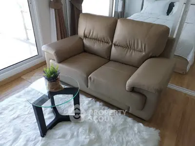 Cozy living room with plush sofa and glass coffee table on a soft rug