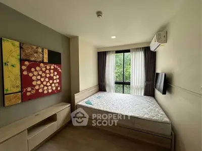Modern bedroom with large window and stylish decor in a cozy apartment.