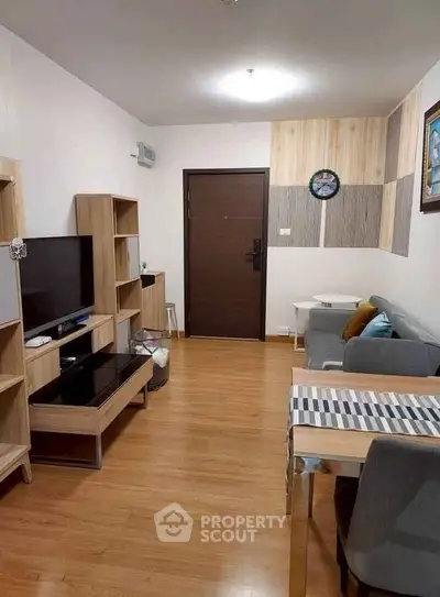 Modern living room with wooden flooring, stylish furniture, and cozy decor.