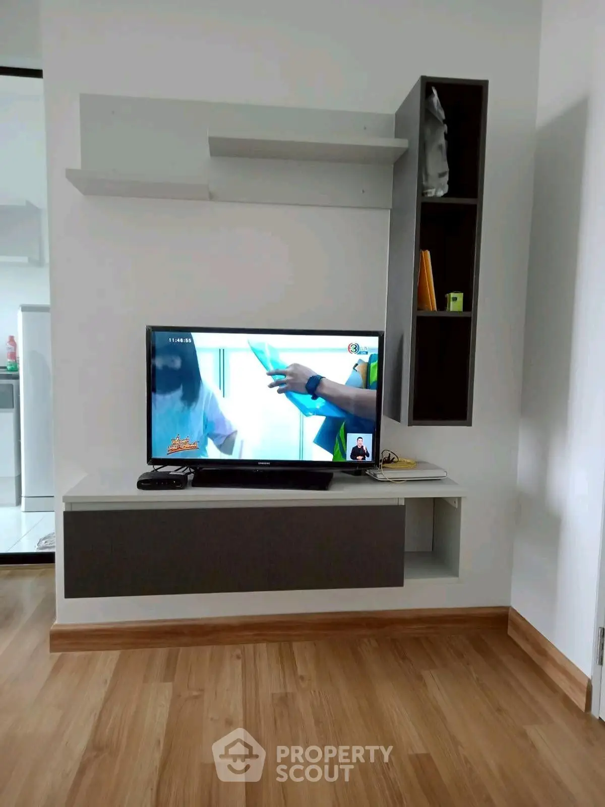 Modern living room with sleek TV setup and wooden flooring