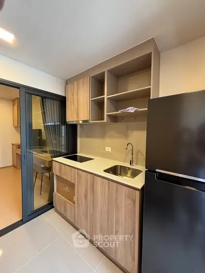 Modern kitchen with sleek cabinetry and stainless steel appliances in a contemporary apartment.