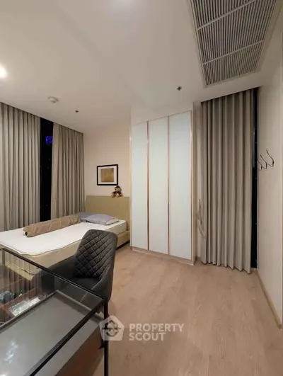Modern bedroom with stylish decor and large windows in a contemporary apartment.