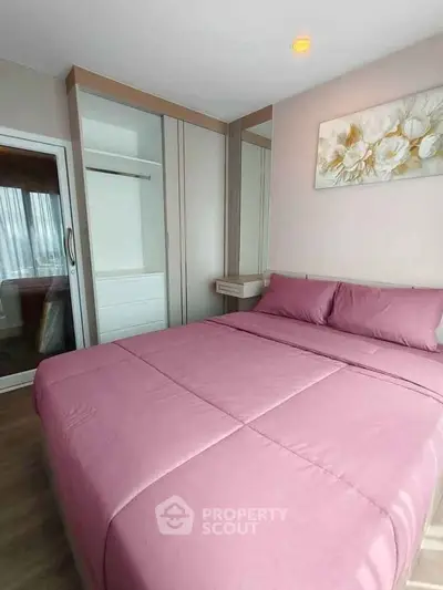 Cozy bedroom with pink bedding and modern wardrobe in a stylish apartment.