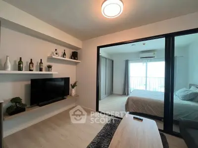 Modern living room with sleek TV setup and cozy bedroom view