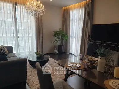 Elegant living room with chandelier, modern furniture, and large windows for natural light.