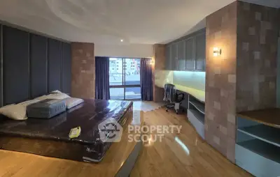 Spacious bedroom with modern design and built-in study area, featuring wooden flooring and large windows.