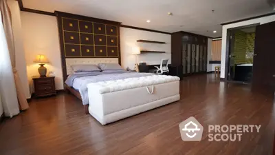 Spacious bedroom with elegant decor and wooden flooring