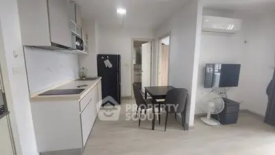Modern open-layout kitchen and dining area with sleek appliances and minimalist design.