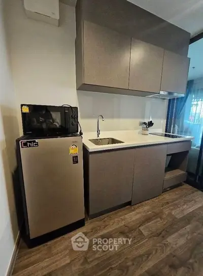 Modern kitchen with sleek cabinetry and compact appliances in a stylish apartment.