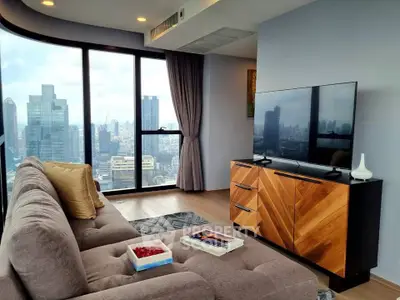 Luxurious living room with panoramic city views and modern decor in high-rise apartment.