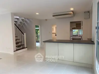 Spacious open-plan living area with modern kitchen and staircase