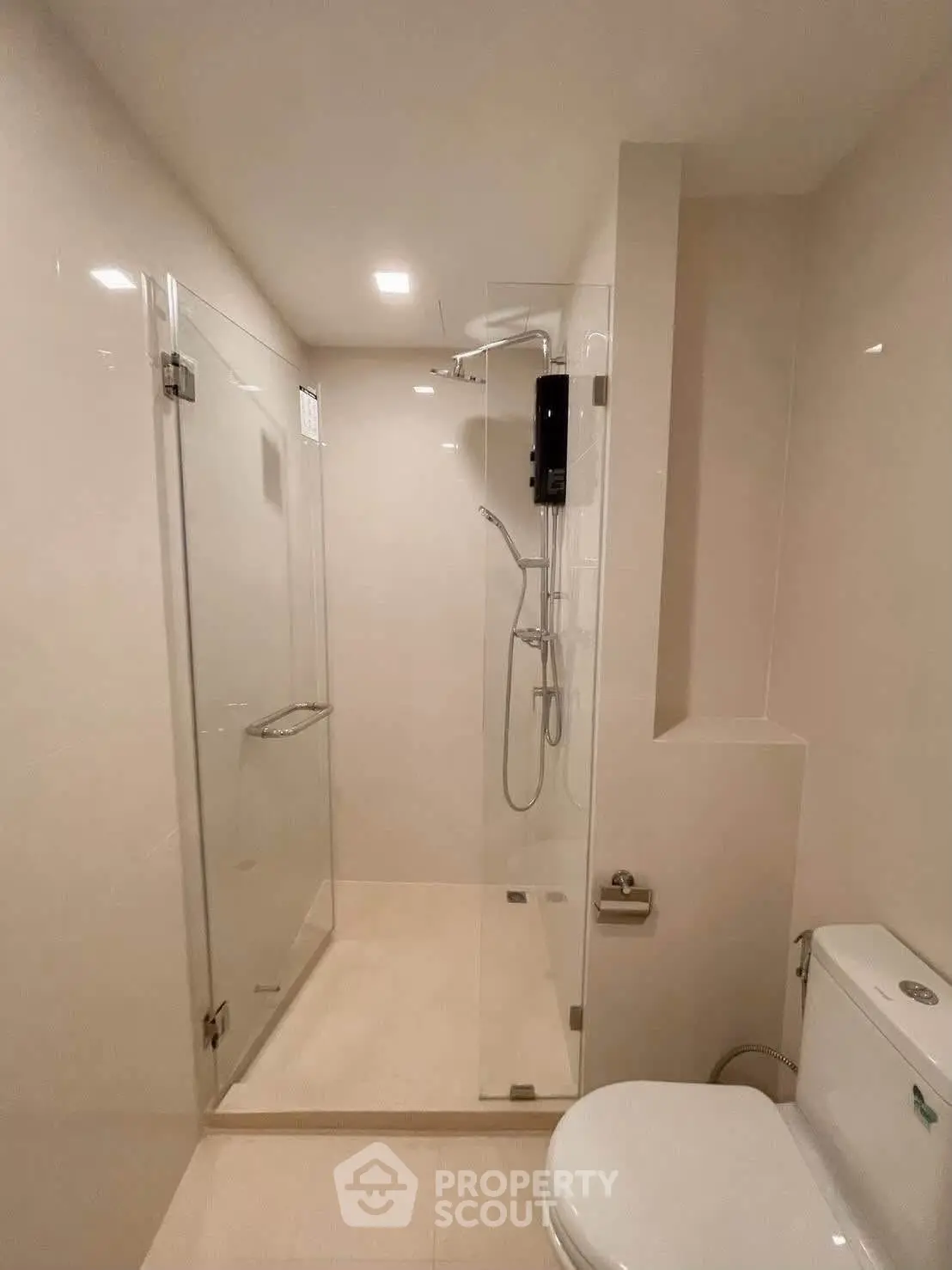 Modern bathroom with glass shower enclosure and sleek fixtures.