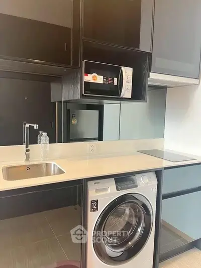 Modern kitchen with sleek appliances and integrated washing machine