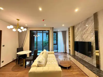 Modern living room with elegant decor, large TV, and stylish lighting in a luxurious apartment.