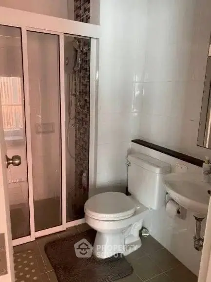 Modern bathroom with glass shower and sleek fixtures in a contemporary apartment.